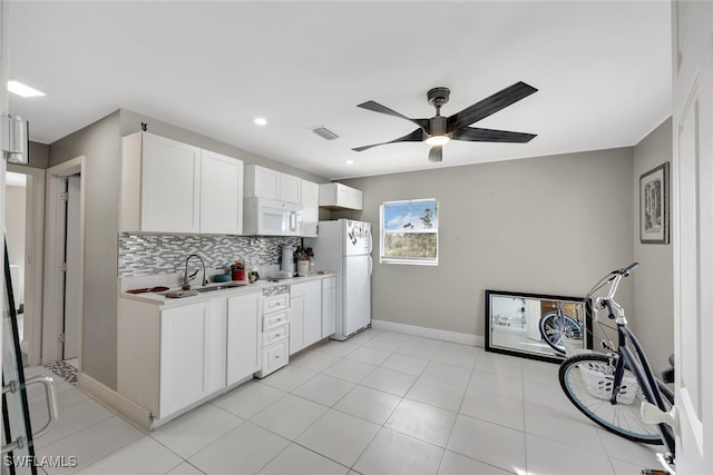 kitchen featuring white appliances, white cabinets, tasteful backsplash, sink, and ceiling fan