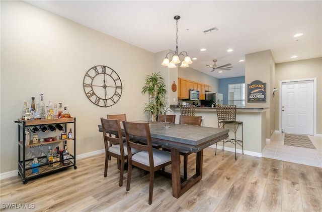 dining area with light hardwood / wood-style floors and ceiling fan