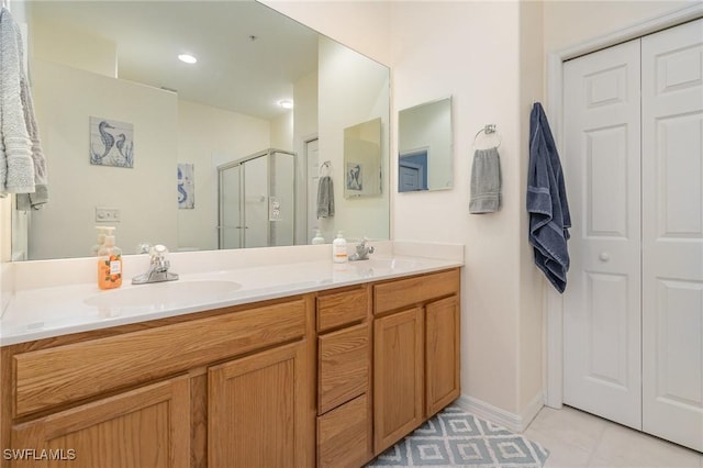 bathroom featuring a shower with door, vanity, and tile patterned floors