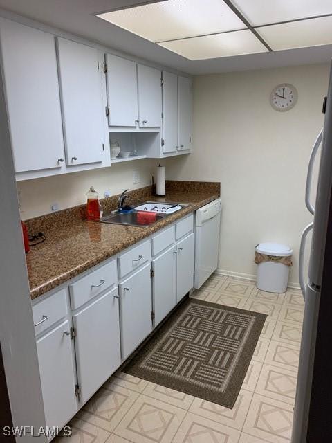 kitchen featuring stainless steel fridge, white dishwasher, sink, and white cabinets