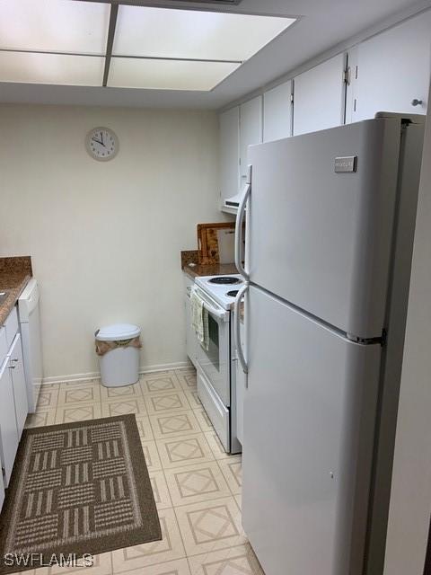 kitchen featuring white cabinets and white appliances