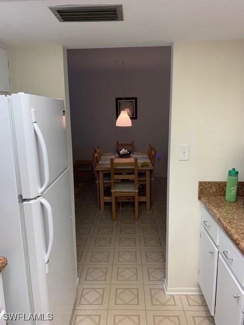 kitchen with white fridge and white cabinets