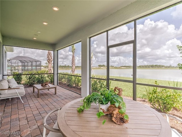 sunroom featuring a water view