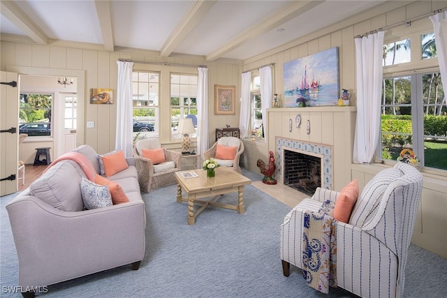 sunroom / solarium featuring a tile fireplace, plenty of natural light, and beamed ceiling