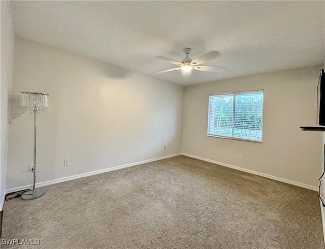 carpeted spare room featuring ceiling fan and a textured ceiling