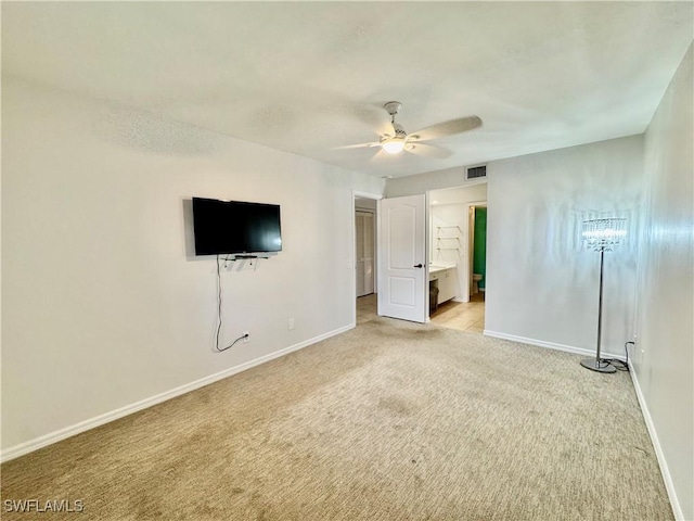 unfurnished bedroom featuring light carpet, connected bathroom, and ceiling fan