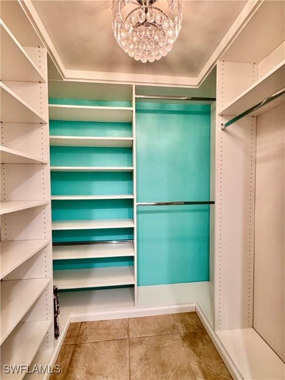 spacious closet with a chandelier