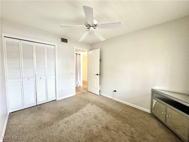 unfurnished bedroom with carpet floors, ceiling fan, and a closet