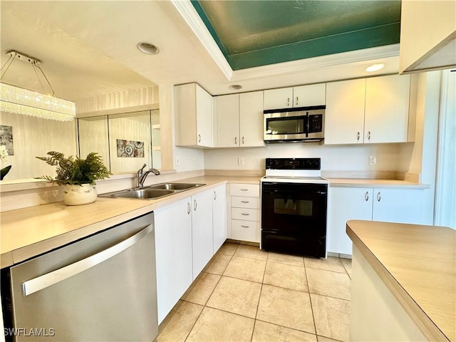 kitchen with sink, light tile patterned floors, appliances with stainless steel finishes, a tray ceiling, and white cabinets