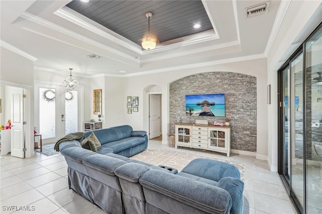 tiled living room with a tray ceiling and ornamental molding