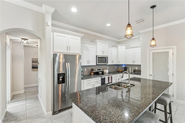 kitchen featuring sink, crown molding, stainless steel appliances, a kitchen island with sink, and white cabinets