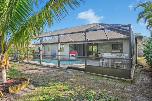 rear view of house featuring a fenced in pool, a patio, and glass enclosure