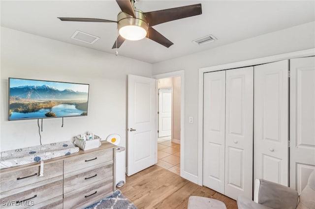 bedroom with light hardwood / wood-style flooring, a closet, and ceiling fan