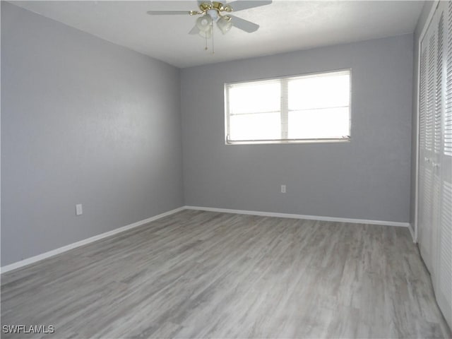 unfurnished bedroom featuring ceiling fan, a closet, and light wood-type flooring