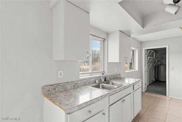 6135 Markland Ave, Fort Myers, FL 33916 - kitchen featuring white cabinets, light countertops, a sink, and gas water heater