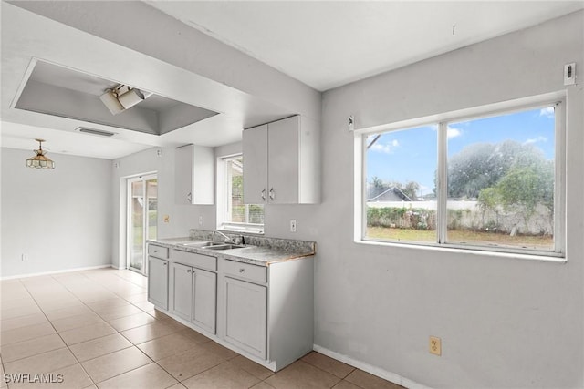 6135 Markland Ave, Fort Myers, FL 33916 - kitchen with light tile patterned floors, a tray ceiling, light countertops, a sink, and baseboards