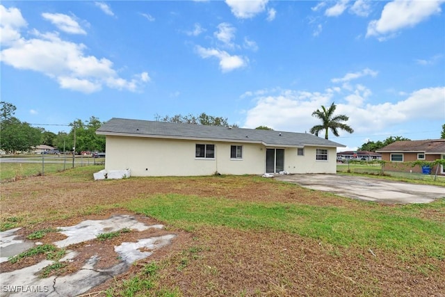 6135 Markland Ave, Fort Myers, FL 33916 - back of property with fence, a lawn, and stucco siding