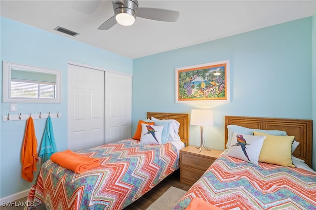 bedroom with dark hardwood / wood-style floors, a closet, and ceiling fan