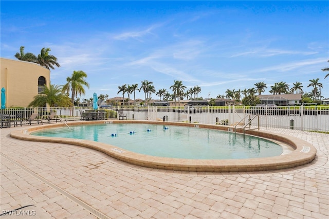 view of pool featuring a patio and a water view