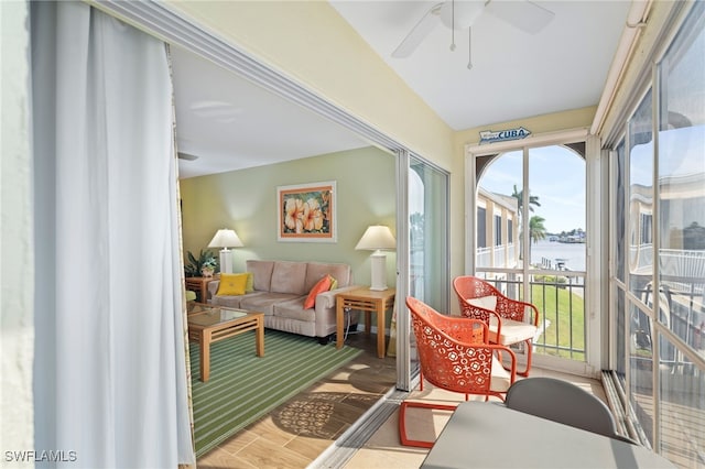 sunroom / solarium featuring vaulted ceiling, a water view, and ceiling fan