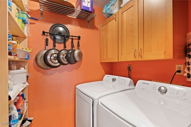 washroom featuring cabinets and washing machine and dryer