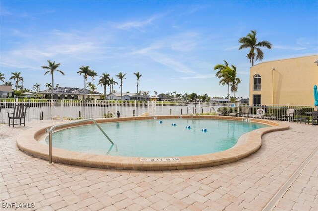 view of swimming pool with a water view and a patio