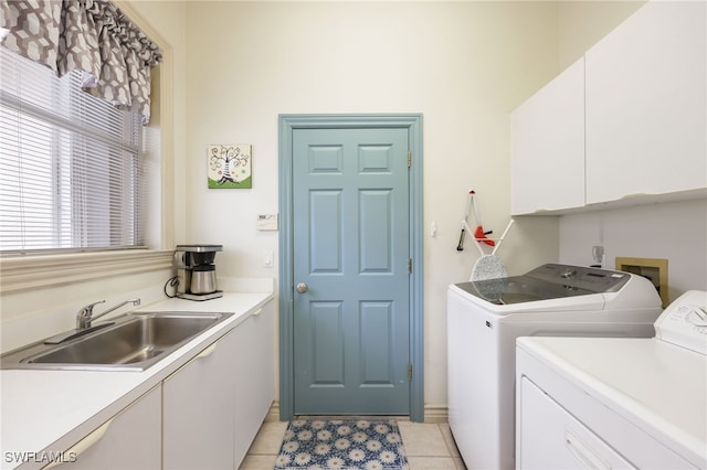 laundry room featuring sink, washing machine and dryer, light tile patterned floors, and cabinets