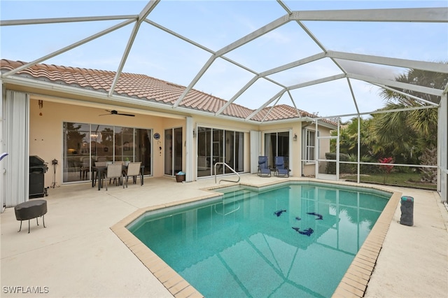 view of swimming pool with glass enclosure, a patio area, a grill, and ceiling fan