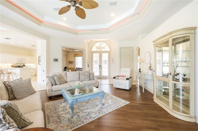 living room with french doors, dark hardwood / wood-style floors, ceiling fan, and a raised ceiling