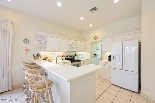 kitchen with light tile patterned floors, white appliances, white cabinets, and sink