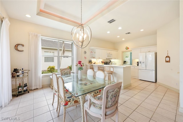 tiled dining area featuring a chandelier, a tray ceiling, and ornamental molding