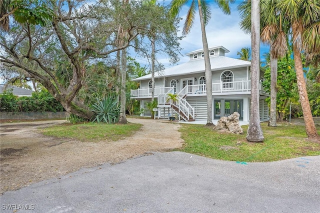 beach home with a porch and a front yard