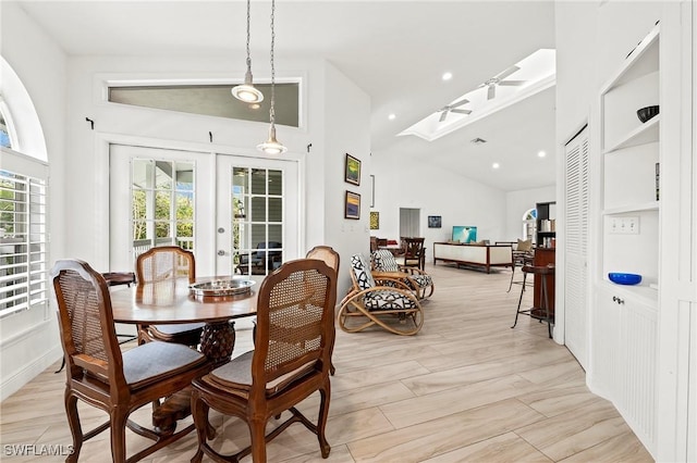 dining space with vaulted ceiling with skylight and french doors