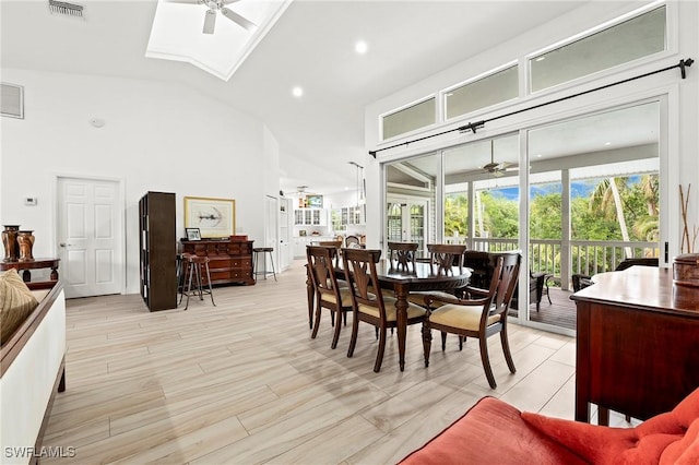 dining space featuring high vaulted ceiling, ceiling fan, and a skylight