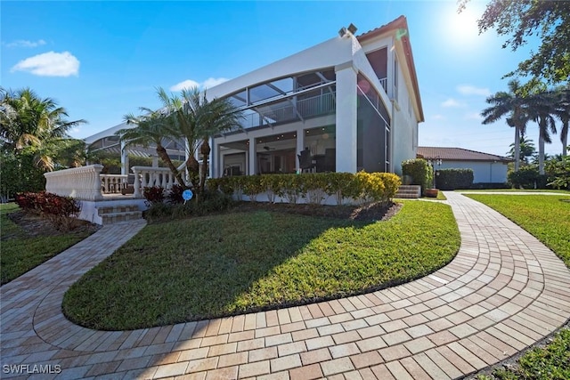 exterior space featuring a lawn and a balcony