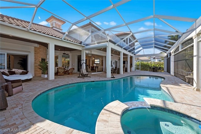 view of swimming pool featuring a patio, an outdoor hangout area, ceiling fan, and glass enclosure