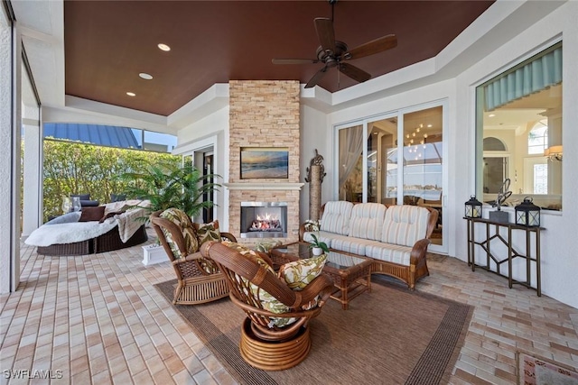 view of patio featuring ceiling fan and an outdoor living space with a fireplace