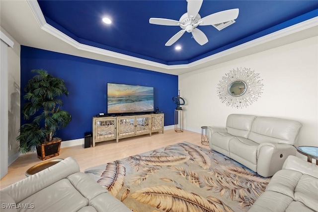 living room with crown molding, ceiling fan, a tray ceiling, and hardwood / wood-style floors