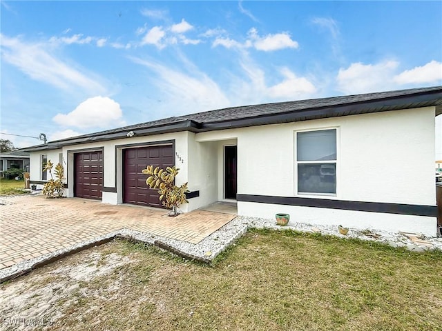 ranch-style home featuring a garage and a front lawn