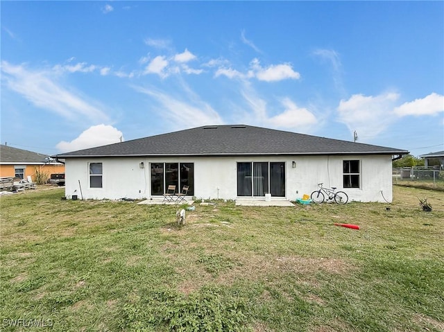 rear view of property featuring a yard