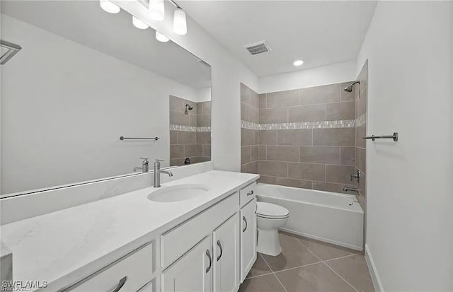 full bathroom with tiled shower / bath combo, vanity, tile patterned floors, and toilet