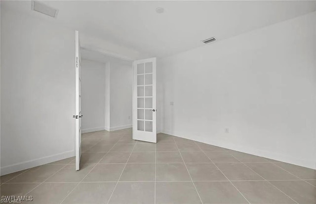 unfurnished room featuring french doors and light tile patterned floors