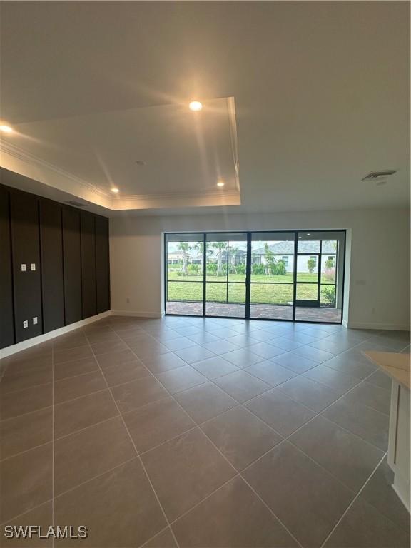 spare room featuring tile patterned floors and a tray ceiling