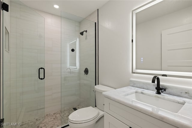 bathroom featuring vanity, an enclosed shower, and toilet