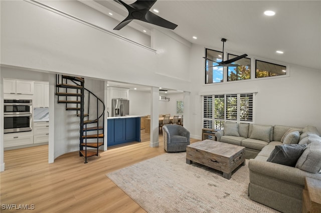 living room with high vaulted ceiling, ceiling fan, and light hardwood / wood-style floors