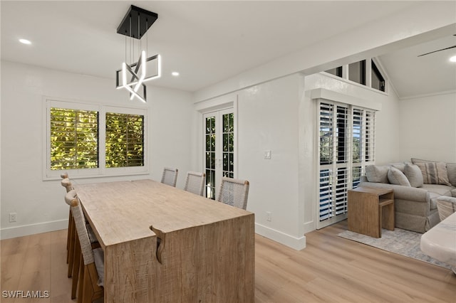 dining room featuring french doors, vaulted ceiling, and light hardwood / wood-style flooring