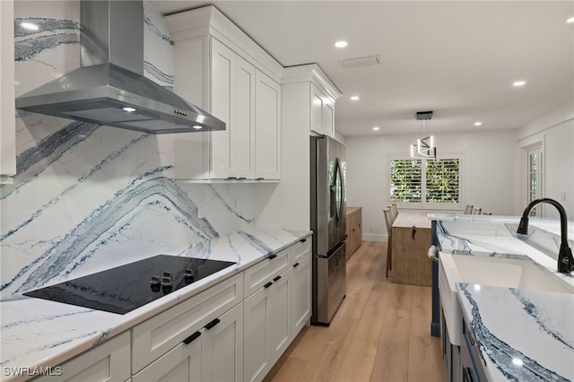 kitchen featuring white cabinetry, black electric cooktop, exhaust hood, and stainless steel refrigerator with ice dispenser