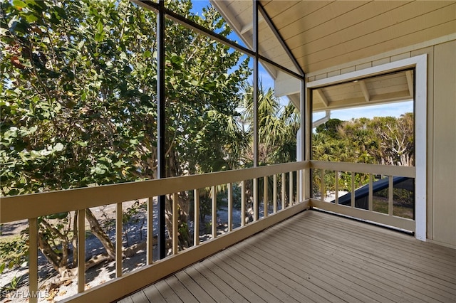 unfurnished sunroom featuring vaulted ceiling