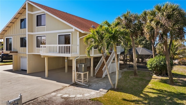 back of house with a garage, a lanai, and cooling unit