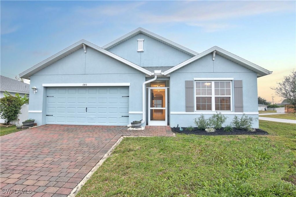 view of front of home with a garage and a yard